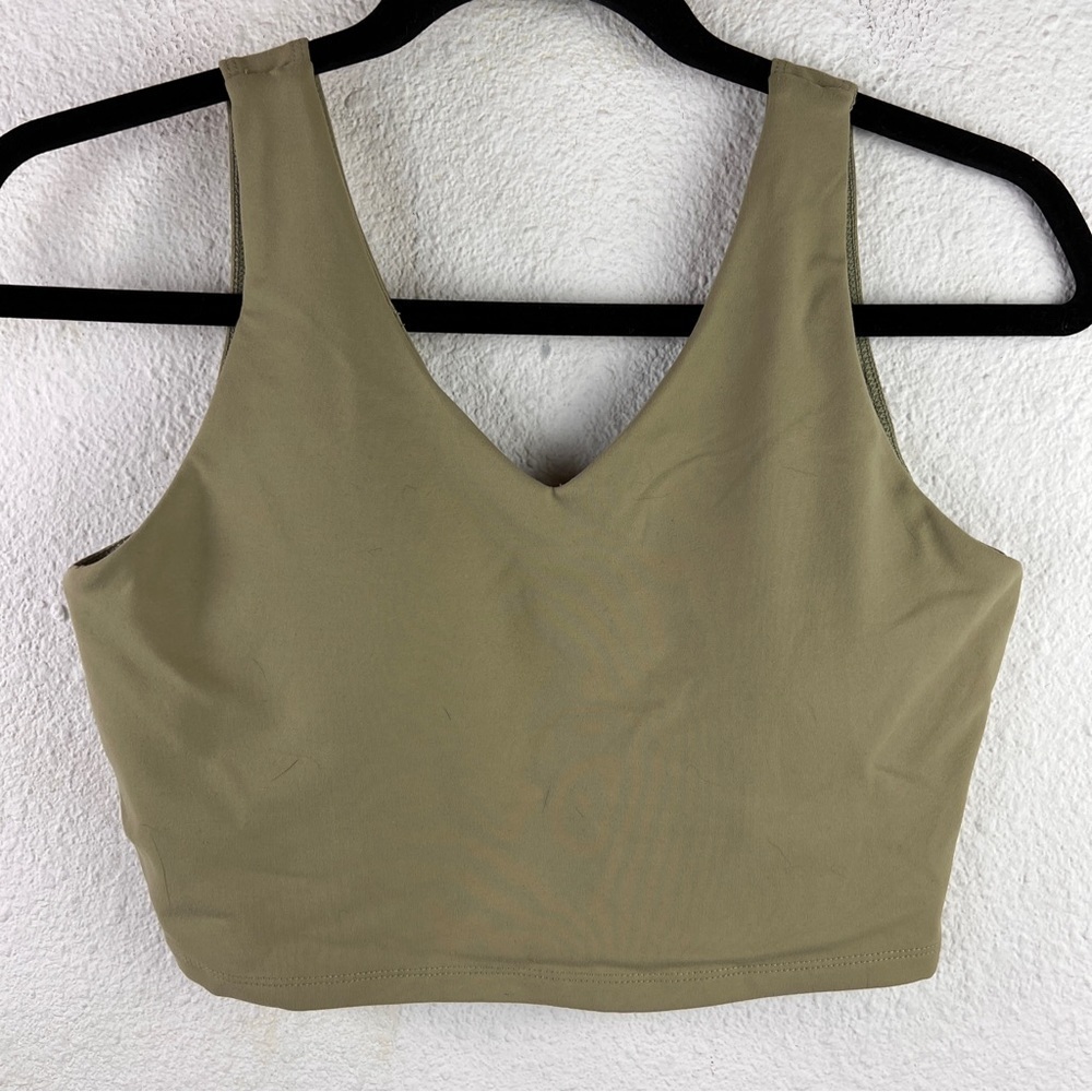 NWOT SPORTS BRA. Size Medium. Green pullover with cross-cross back. Padded